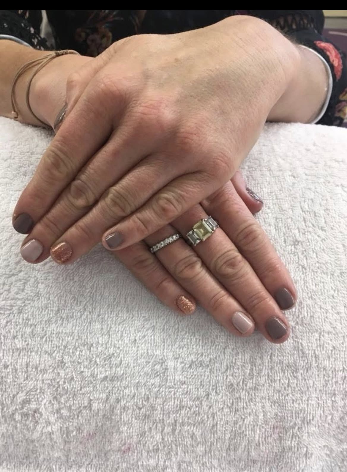 Pedicure finished in hot pink gel polish, worn in fluffy black slides.