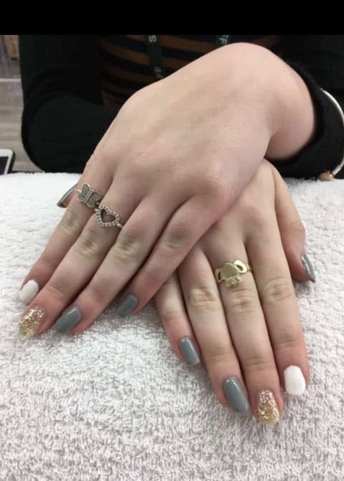 Classic red gel manicure on mature hands resting on a navy towel.