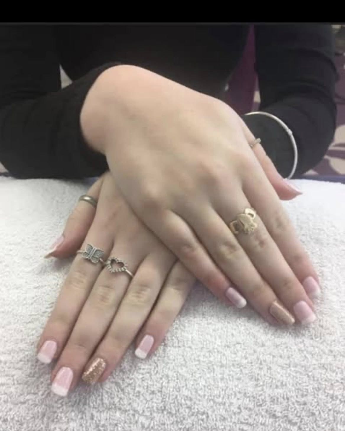 Almond-shaped nude manicure with delicate silver glitter accent.