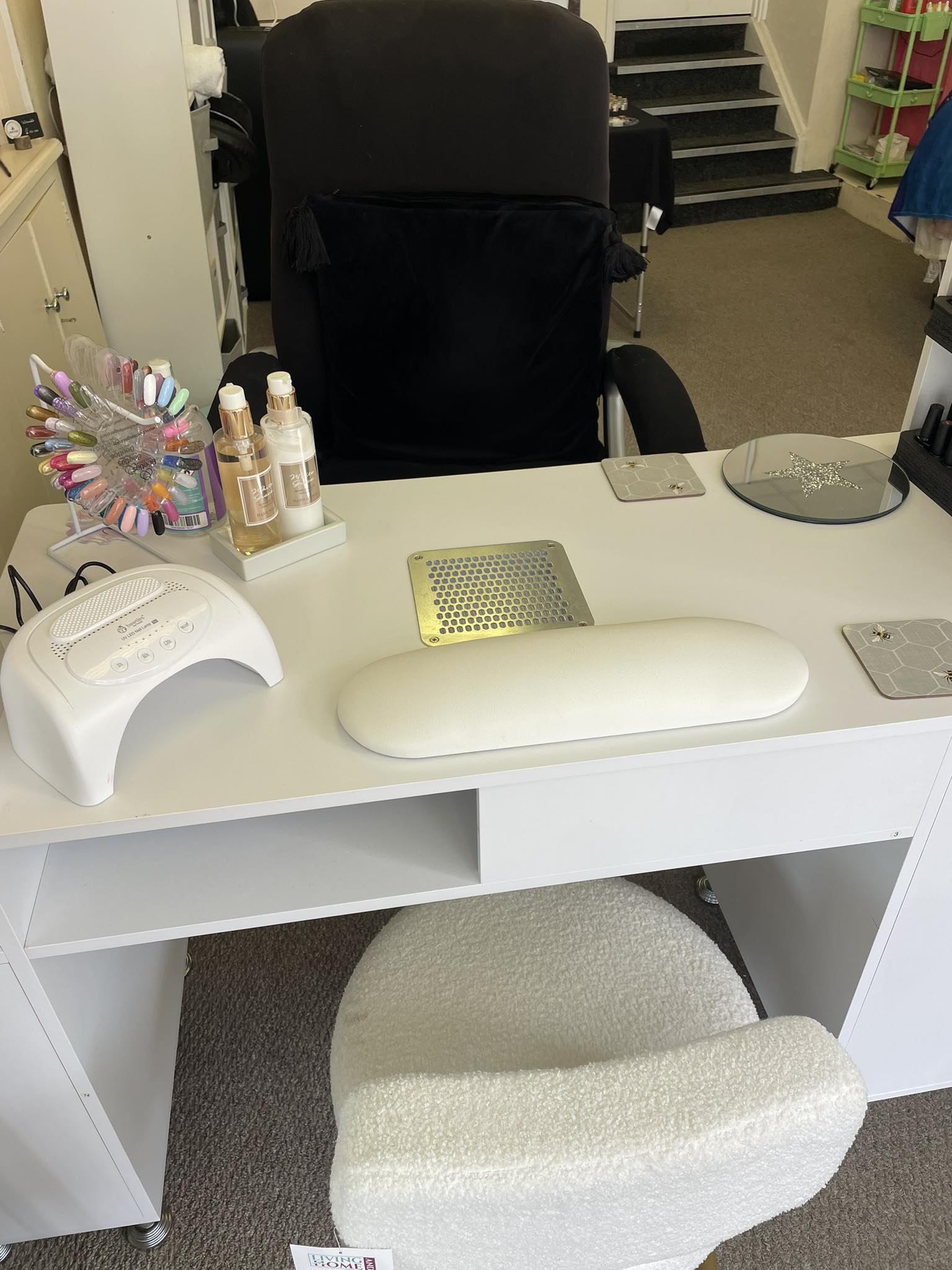 Selina's nail workstation upstairs at Willow Tree Therapies — white desk, professional curing lamp, polish rack, dust extractor and salon chair.